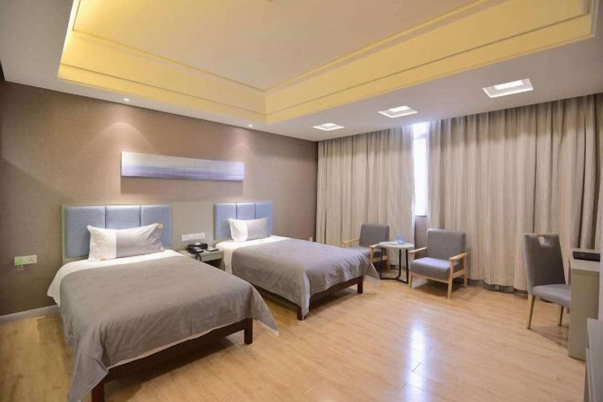 Una habitación de hotel con dos camas, una mesita, una silla y un escritorio.