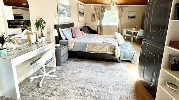 A cozy bedroom with a bed, desk, and dresser. There is a window with curtains and a view of the outdoors. - private suite (the skylight) (Lower Sackville)