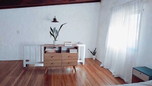 Ein Zimmer mit einem Holzkasten, einem Heizkörper und einer Topfpflanze.