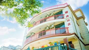 A multi-story building with balconies and a staircase.