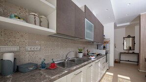 A modern kitchen with white cabinets, a granite countertop, and a built-in oven.