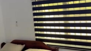 Un dormitorio con cama, ropa de cama blanca, una ventana con persianas y un equipo de aire acondicionado en la pared.