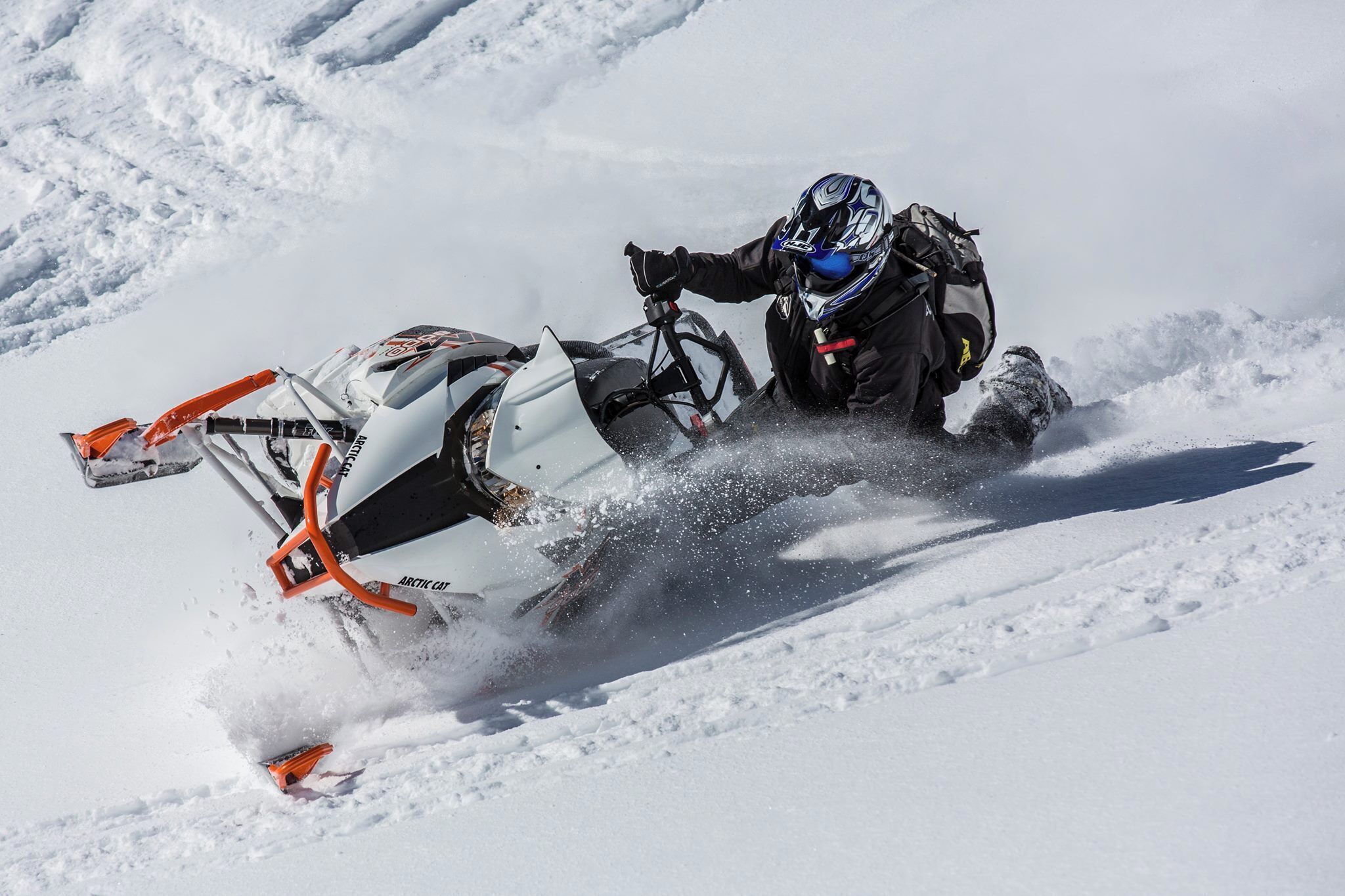 A person on a snowmobile in a snowy landscape.