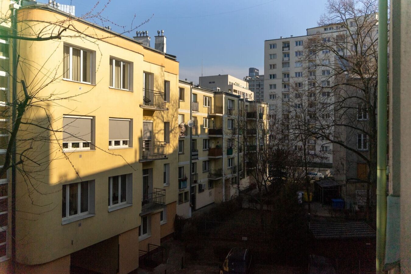 Un immeuble résidentiel à plusieurs étages, doté de balcons et d’une cour intérieure.