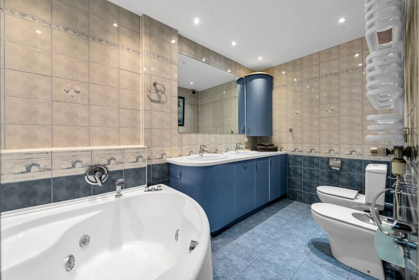 Un baño moderno con una bañera independiente, un tocador doble y un inodoro.