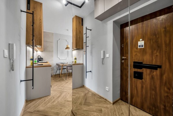 A modern kitchen with wooden cabinets, a dining area, and a wooden door with a lock.