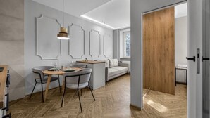 Un interior moderno con zona de comedor, sofá y puerta de madera.