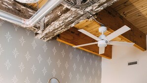 Un dormitorio con una cama grande, cabecera de madera y un ventilador de techo.