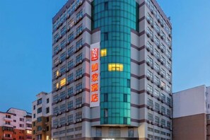 A multi-story hotel with a prominent vertical sign indicating a hotel name. - Homeinn · neo (Fushun Jiangjun Bridge Wanda Plaza) (Fushun)