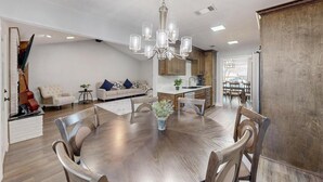 A spacious living area with a dining table, sofas, and a chandelier. - Spacious 5-bedroom house with WIFI and newly furnished in fabulous Arlington. (Arlington)