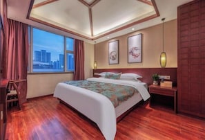 Une chambre d’hôtel dotée d’un grand lit, offrant une vue sur la ville, avec un parquet en bois et un design moderne au niveau du plafond.