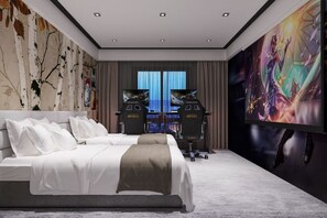 A modern hotel room with a large bed, a flat-screen TV, and a gaming setup. - Xingji Hotel (Tiantai County)