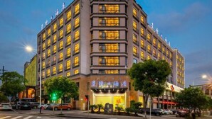 A multi-story hotel with a prominent entrance and illuminated signage. - Xingji Hotel (Tiantai County)