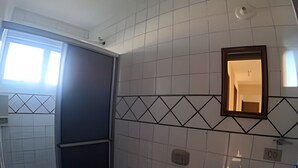 A bathroom with a toilet, sink, and shower area. - Conforto Praia de Leste (Pontal do Parana)
