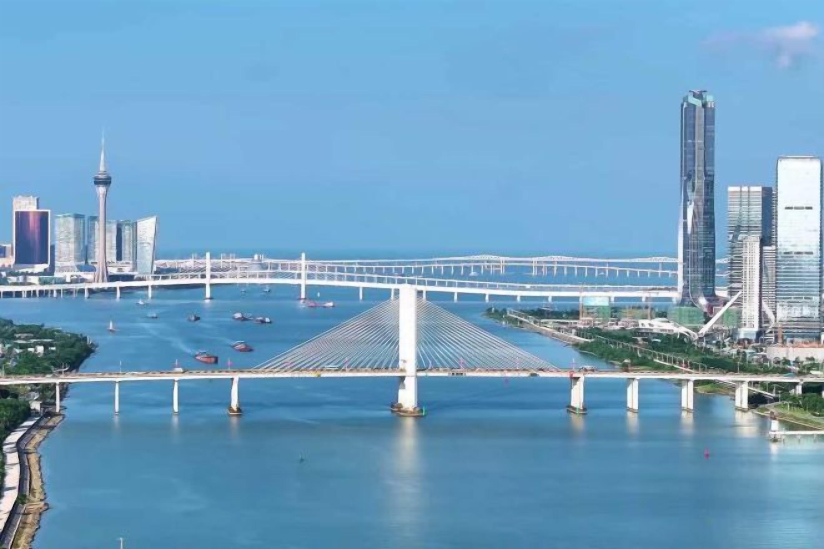 Un puente cruza un río con el perfil urbano de una ciudad al fondo.