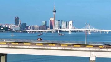 A city skyline with a prominent tower and a bridge over water.
