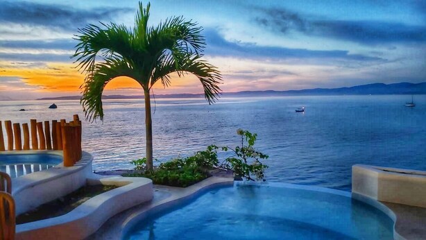 A poolside area with a view of the sea and sunset. - Right in front of the sea! Maguey House (La Manzanilla)