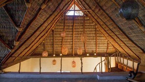An attic room with a thatched roof, wooden beams, and hanging woven light fixtures. - Right in front of the sea! Maguey House (La Manzanilla)