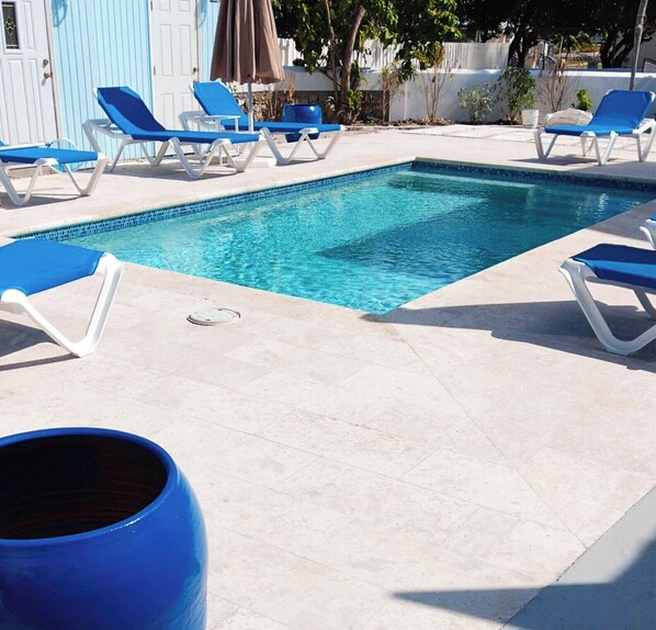 حمّام سباحة خارجي، مظلات على حمّام السباحة، مقاعد للتشمس