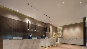 A modern reception area with marble counters and pendant lighting. - Jade Crystal Hotel (Taizhou)