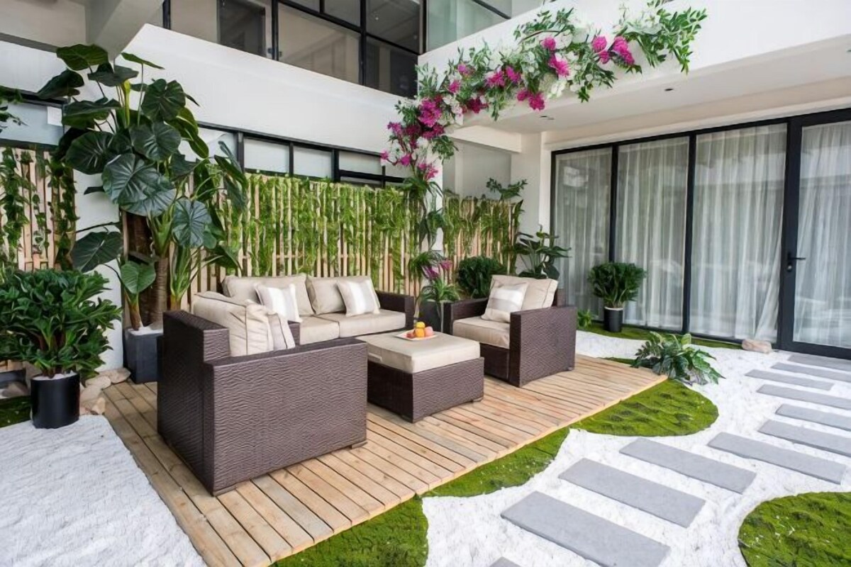A modern outdoor living area with a sofa set, a coffee table, and potted plants.