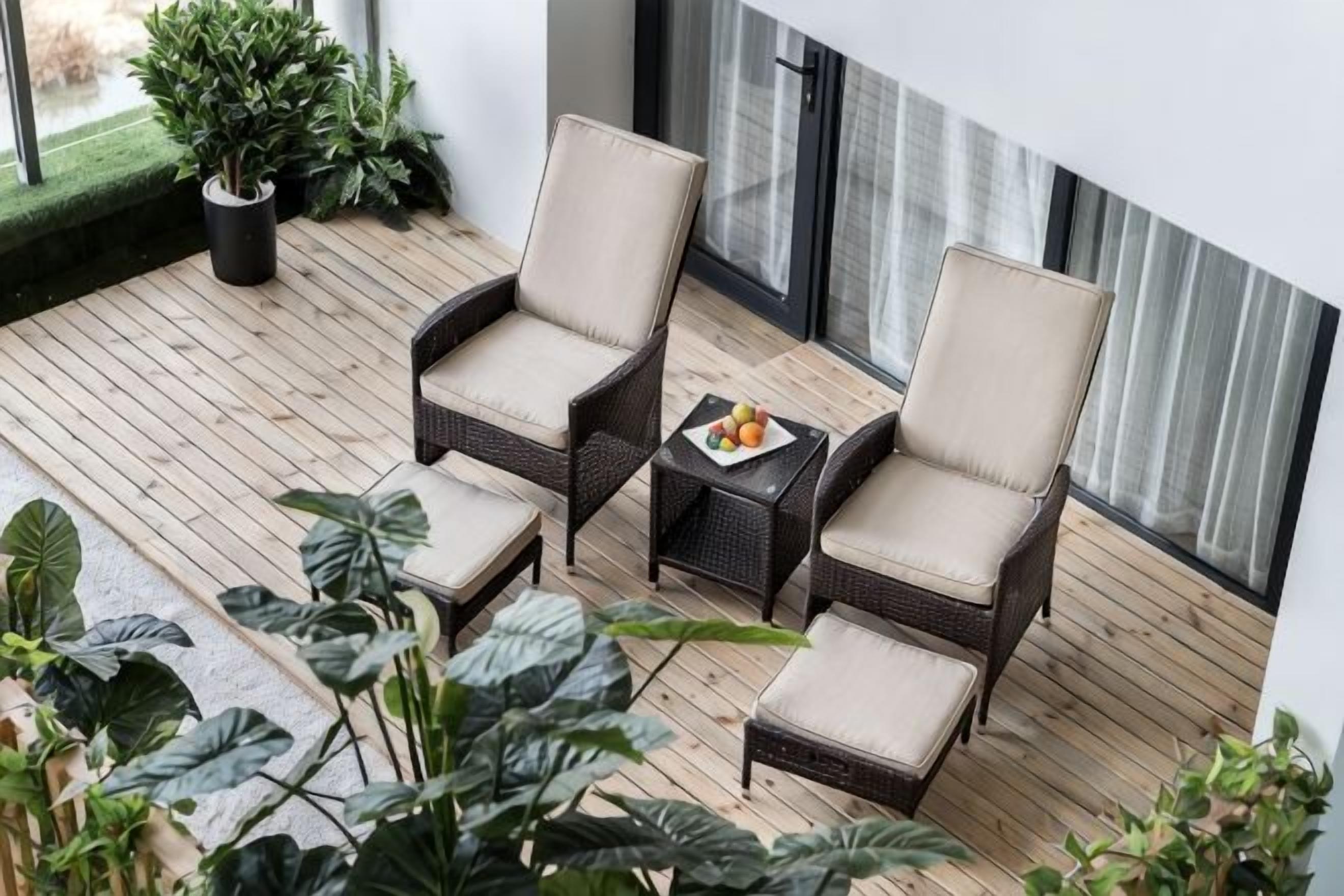 Een balkon met rieten meubels en een kleine tafel met fruit.