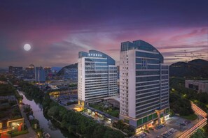 Een hotel met een modern design, met een ruime parkeerplaats en uitzicht op de rivier.