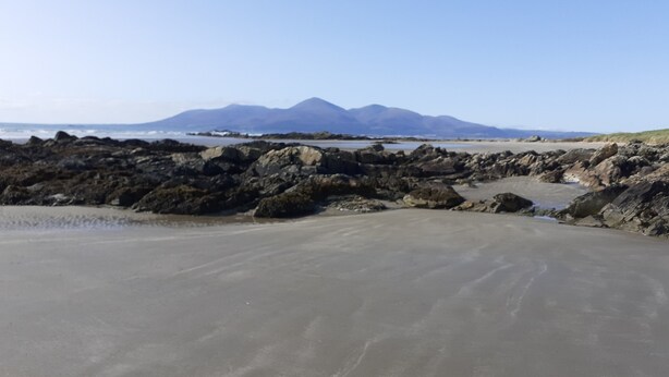 A beach with rocky terrain and a distant mountain range. - The Cottage at The Burren Tyrella - your coastal base for the Mourne country. (Downpatrick)