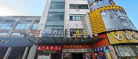 A multi-story building with various commercial establishments on the ground floor, including a hotel and a KTV.