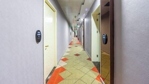 A hotel corridor with a patterned carpet, doors with room numbers, and a ceiling with recessed lighting. - Shangji Hotel (Shanghai Hongqiao Airport ,West Xianxia Road ) (Shanghai)