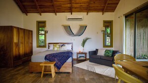 Ein Schlafzimmer mit Bett, Holzmöbeln, einem Fenster und einer Klimaanlage.