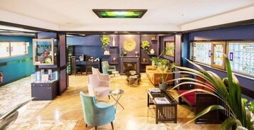 Um hall moderno com lareira, área de estar e exposição de arte local.