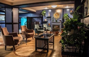 Uma sala de estar moderna com poltronas de couro, uma mesa de centro de vidro e uma lareira.