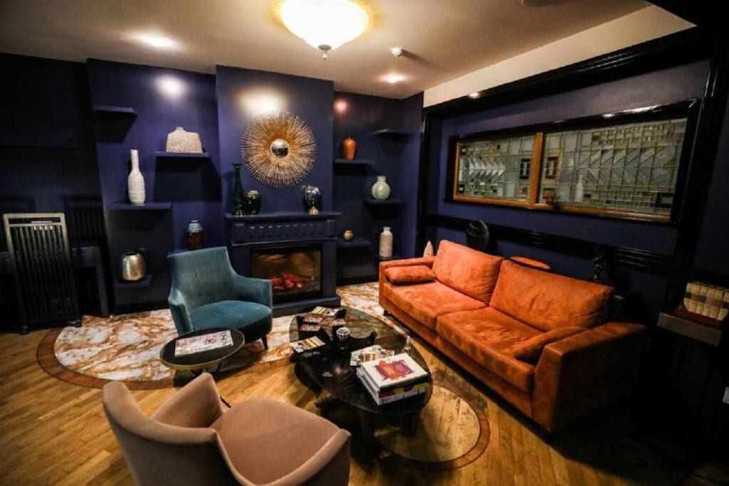 A modern living room with a fireplace, a large window with a view, and a cozy seating area.