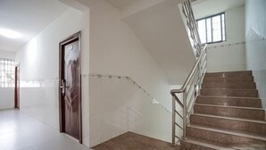 A staircase with a handrail, a door with a handle, and a window. - Yijia Apartment (Xiamen Airport) (Xiamen)