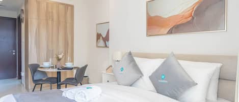 Et hotelværelse med en seng, et skrivebord og en stol.