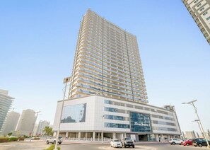 A high-rise hotel with a modern design, featuring a prominent glass facade and a distinctive curved structure.