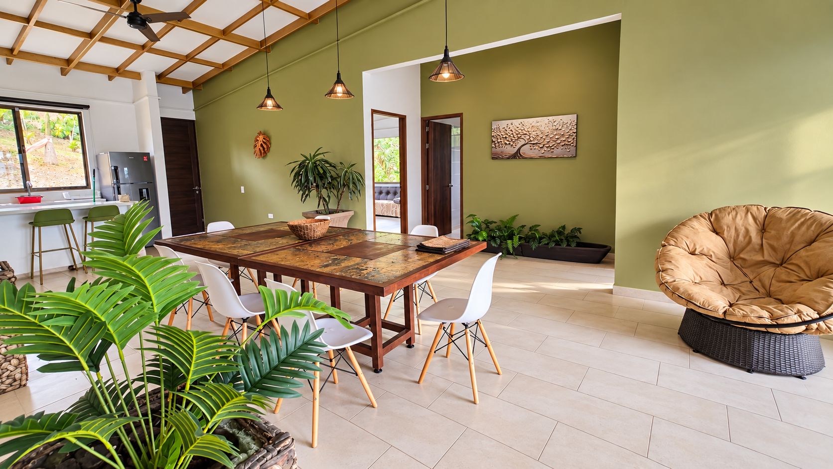 Un espace repas avec une table en bois, des chaises blanches et des lampes suspendues.