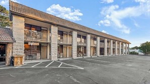 A hotel with a long, single-story structure, multiple balconies, and a parking lot. - 2 Queen Beds  Fast WiFi 50" TV  Salt Water Pool (Eureka Springs)