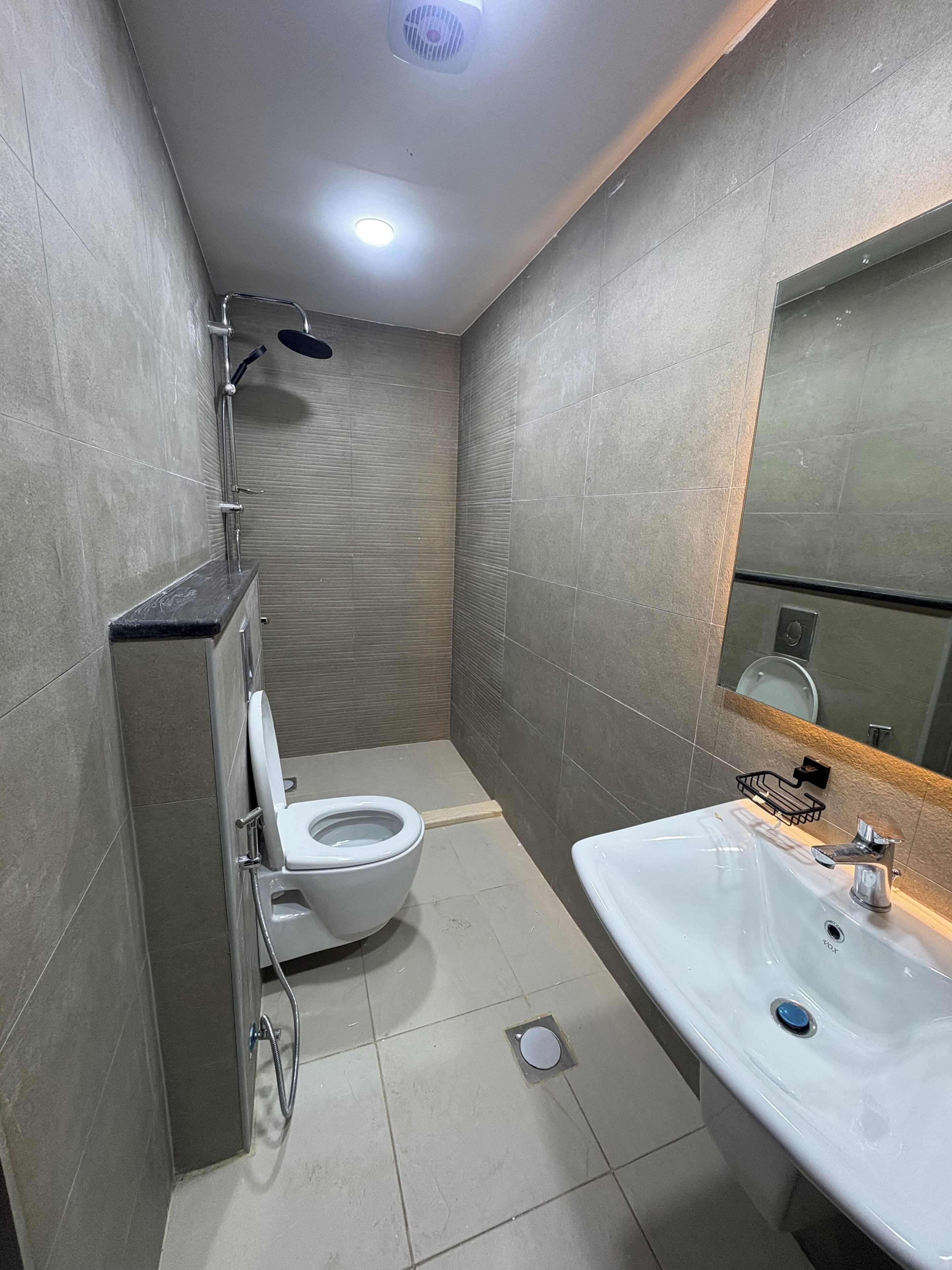 A modern bathroom with a toilet, sink, and shower.