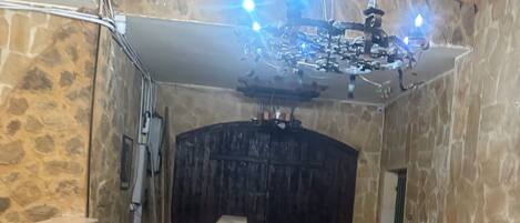 Habitación con paredes y suelo de piedra, un banco de madera, un banco de piedra y una pared de piedra con una puerta.