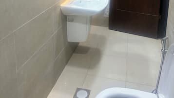 A bathroom with a white sink, a mirror, and a wooden door.