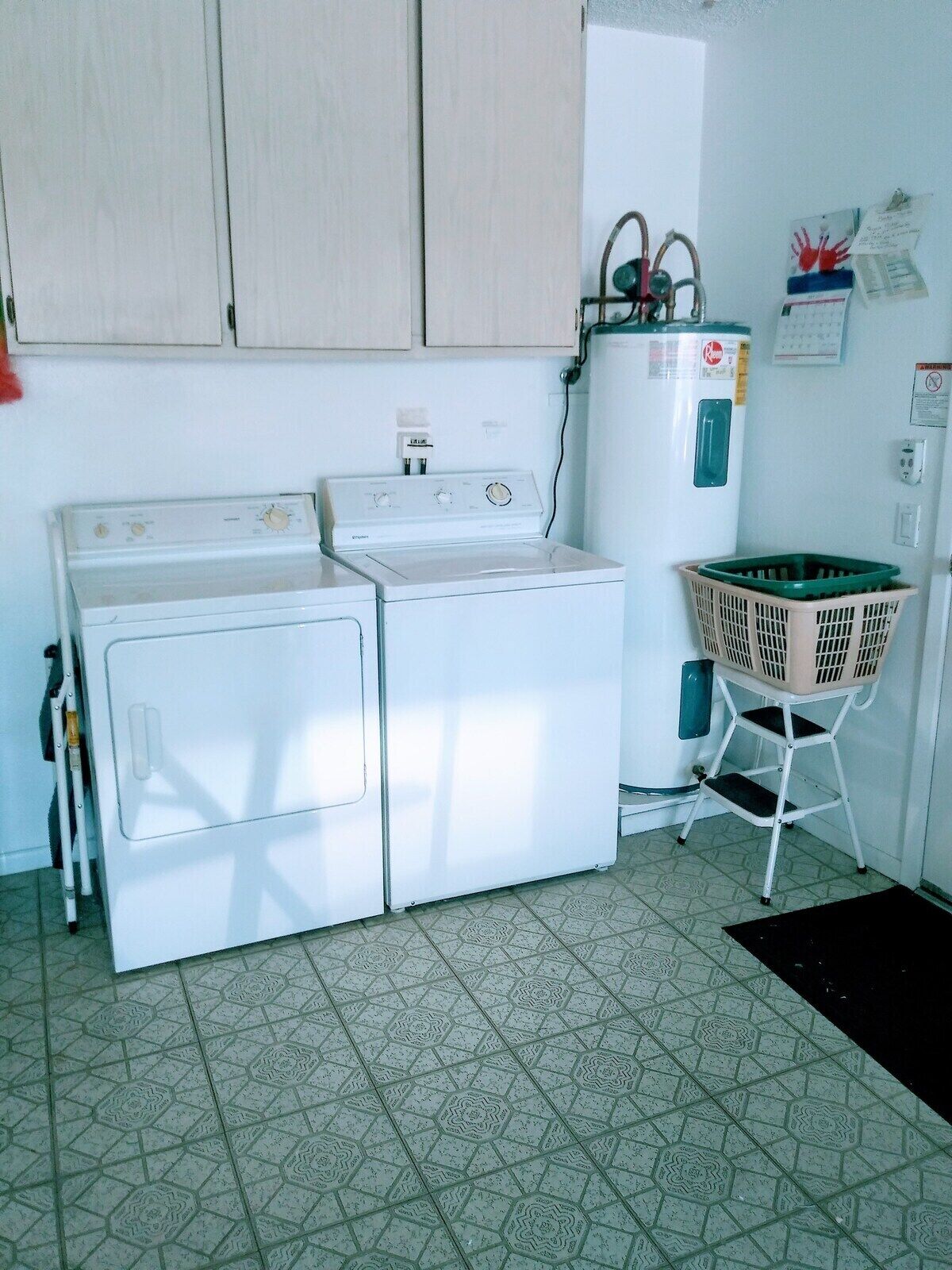 A laundry area with a washing machine, dryer, and stacked laundry basket.