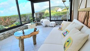 Een modern interieur met een witte bank, een stenen tafel en uitzicht op het platteland.