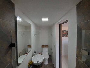 Een douche, handdoeken, zeep, toiletpapier