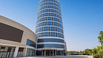 A modern hotel with a curved facade, large glass windows, and a spacious entrance area.