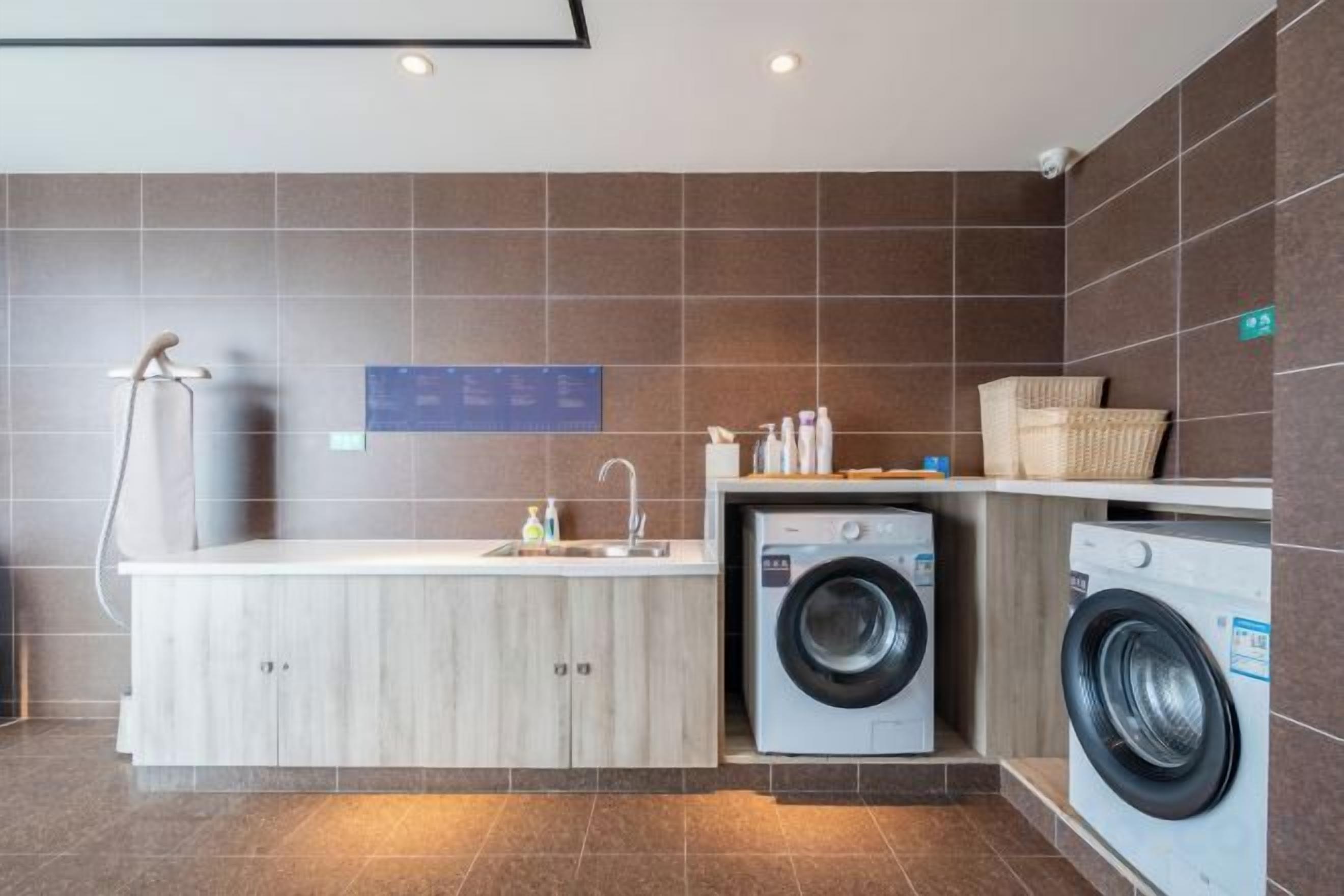 A compact laundry area with a washing machine, a dryer, and a sink.