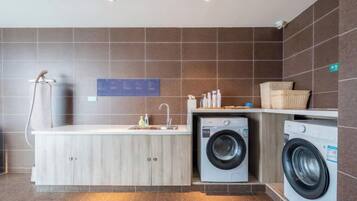 A compact laundry area with a washing machine, a dryer, and a sink.