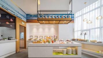 A modern kitchen with a central island, large windows, and pendant lighting.