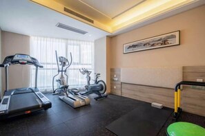 A hotel room with a treadmill, elliptical, and stationary bike. - Xincheng Hotel (Yantai University International Expo Center Branch) (Yantai)
